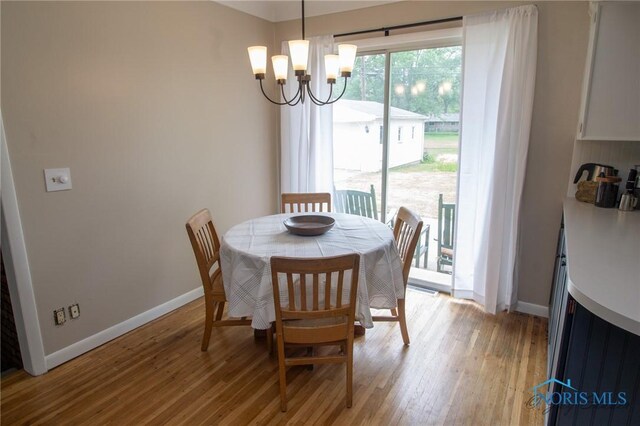 1133 Cuba St, Toledo, OH 43615 - dining room with a chandelier, light wood finished floors, and baseboards