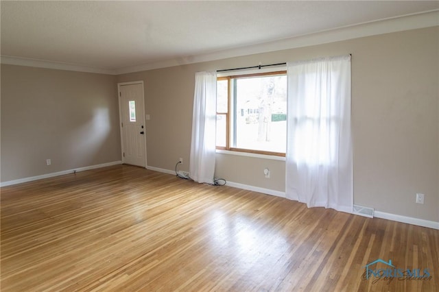 1133 Cuba St, Toledo, OH 43615 - unfurnished living room with light wood finished floors, baseboards, and crown molding