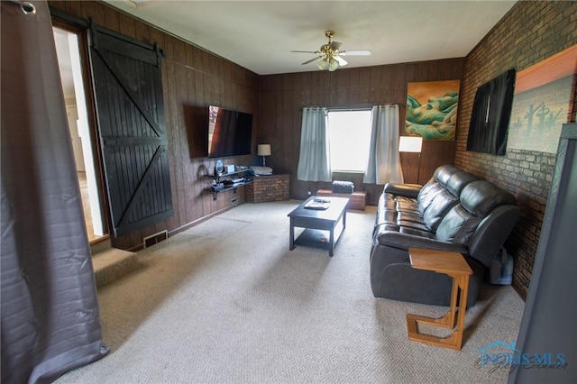1133 Cuba St, Toledo, OH 43615 - living area with a barn door, carpet flooring, ceiling fan, and wood walls