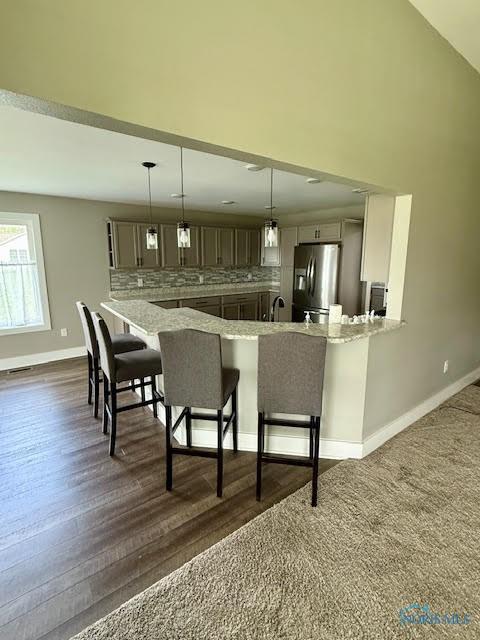 17 Crabtree Ct, Swanton, OH 43558 - kitchen with stainless steel refrigerator with ice dispenser, a peninsula, a kitchen breakfast bar, backsplash, and dark wood-type flooring
