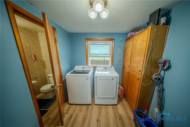 327 Klingler Rd, Paulding, OH 45879 - laundry area with cabinet space, light wood finished floors, and washing machine and clothes dryer