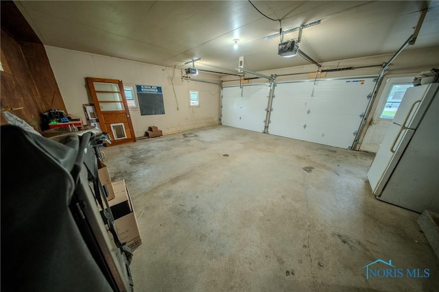 327 Klingler Rd, Paulding, OH 45879 - garage featuring freestanding refrigerator and a garage door opener
