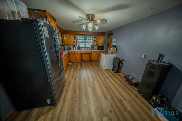 327 Klingler Rd, Paulding, OH 45879 - kitchen featuring freestanding refrigerator, light countertops, brown cabinets, and light wood-style floors