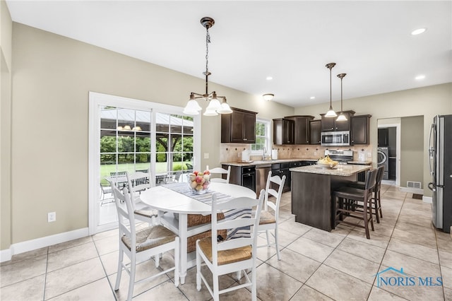 4360 Turtle Creek Dr, Perrysburg, OH 43551 - dining area with washer / clothes dryer, a chandelier, light tile patterned floors, recessed lighting, and baseboards