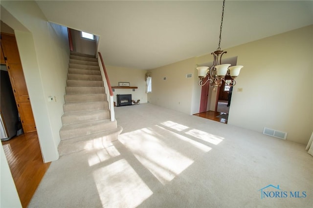 313 E Lynn St, Edgerton, OH 43517 - unfurnished living room with stairs, a chandelier, and carpet