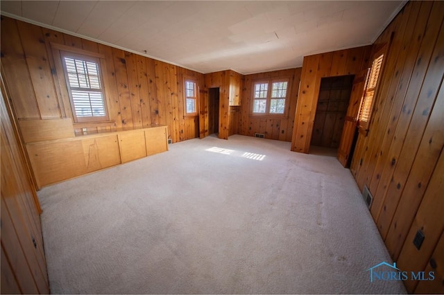 313 E Lynn St, Edgerton, OH 43517 - unfurnished room featuring carpet floors, healthy amount of natural light, wooden walls, and crown molding