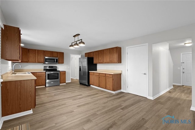 1141 Oriole Dr, Bowling Green, OH 43402 - kitchen featuring stainless steel appliances, a sink, light wood-style flooring, baseboards, and light countertops