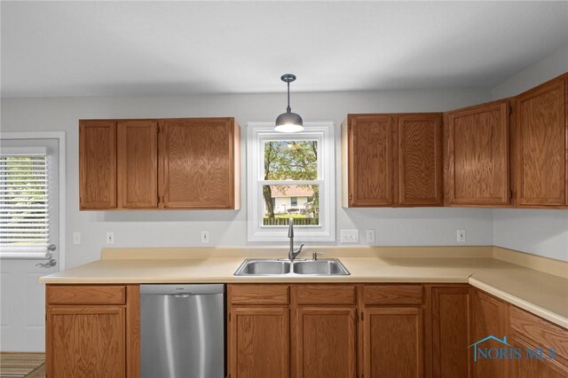 1141 Oriole Dr, Bowling Green, OH 43402 - kitchen with stainless steel dishwasher, a sink, light countertops, hanging light fixtures, and brown cabinetry