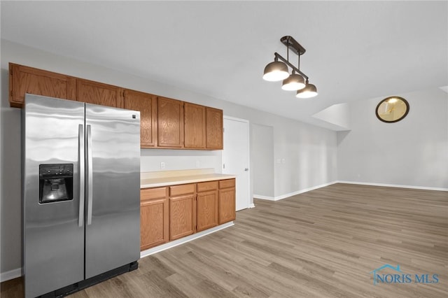 1141 Oriole Dr, Bowling Green, OH 43402 - kitchen featuring stainless steel fridge, light wood-type flooring, light countertops, and brown cabinetry
