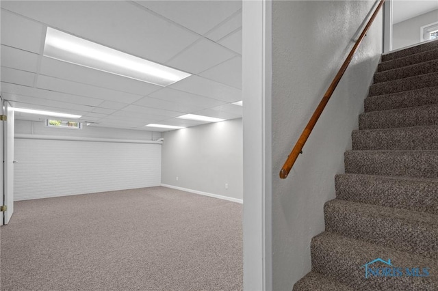 1141 Oriole Dr, Bowling Green, OH 43402 - below grade area with stairs, carpet flooring, baseboards, a paneled ceiling, and brick wall