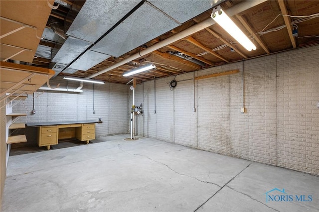 1141 Oriole Dr, Bowling Green, OH 43402 - unfinished basement with a workshop area and brick wall