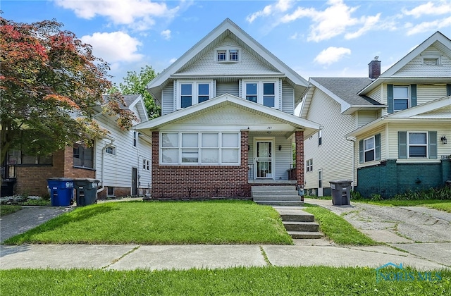 345 W Manhattan Blvd, Toledo, OH 43608 - view of front facade featuring brick siding, a front yard, and a porch
