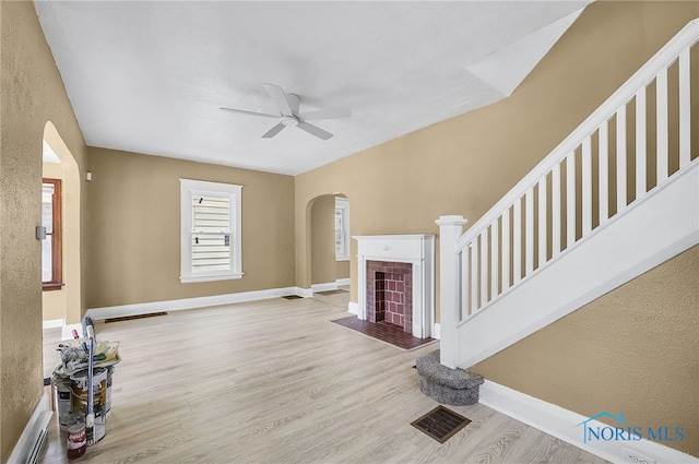 345 W Manhattan Blvd, Toledo, OH 43608 - unfurnished living room with arched walkways, ceiling fan, wood finished floors, and baseboards