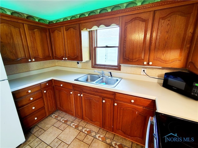 1050 Schultz St, Defiance, OH 43512 - kitchen with a sink, electric range, and brown cabinetry