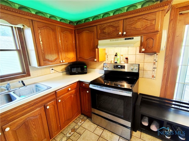 1050 Schultz St, Defiance, OH 43512 - kitchen with stainless steel range with electric stovetop, under cabinet range hood, a sink, and plenty of natural light