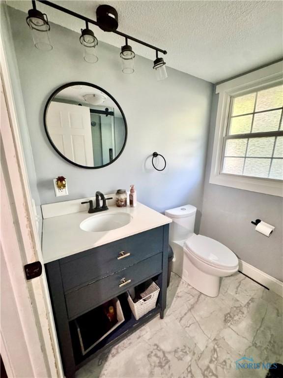 309 Koerber Dr, Defiance, OH 43512 - bathroom featuring marble look tile flooring, vanity, and a textured ceiling