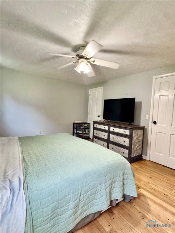 309 Koerber Dr, Defiance, OH 43512 - bedroom with light wood-type flooring, a textured ceiling, and a ceiling fan