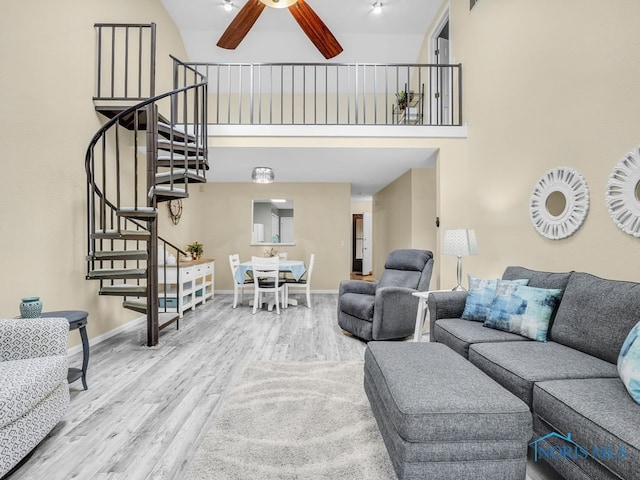 1104 Bernath Pkwy, Toledo, OH 43615 - living area featuring stairway, a towering ceiling, wood finished floors, a ceiling fan, and baseboards
