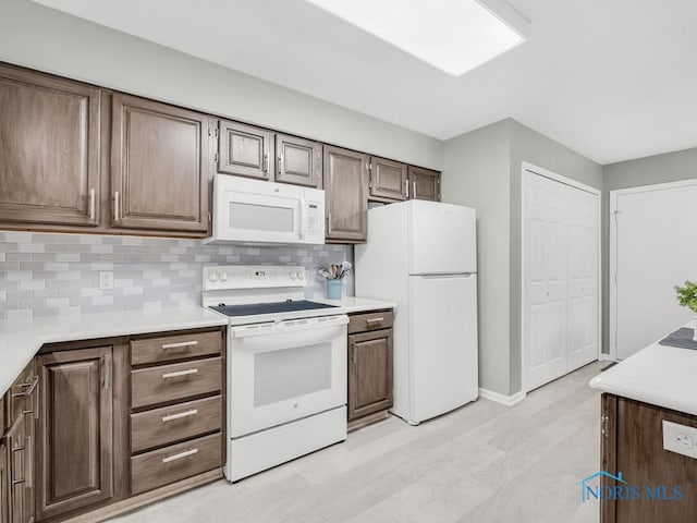 1104 Bernath Pkwy, Toledo, OH 43615 - kitchen featuring white appliances, light countertops, decorative backsplash, and baseboards