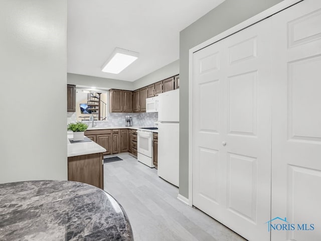 1104 Bernath Pkwy, Toledo, OH 43615 - kitchen featuring white appliances, a sink, light countertops, and tasteful backsplash