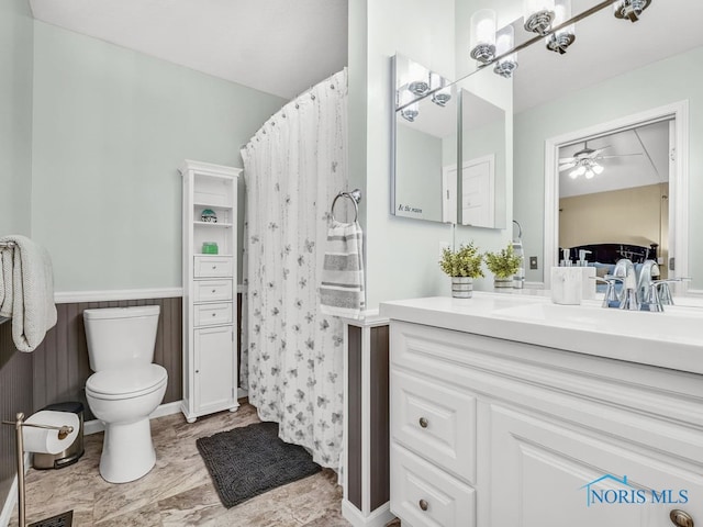 1104 Bernath Pkwy, Toledo, OH 43615 - full bath with ceiling fan, vanity, toilet, a shower with shower curtain, and wainscoting