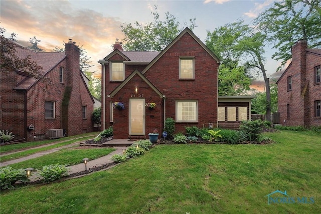3127 Drummond Rd, Toledo, OH 43606 - view of front facade with central air condition unit, a front yard, and brick siding