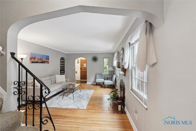 3127 Drummond Rd, Toledo, OH 43606 - living area with stairway, arched walkways, light wood-style floors, crown molding, and baseboards