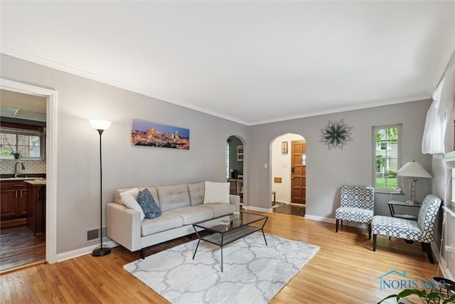 3127 Drummond Rd, Toledo, OH 43606 - living room with arched walkways, light wood finished floors, baseboards, and crown molding