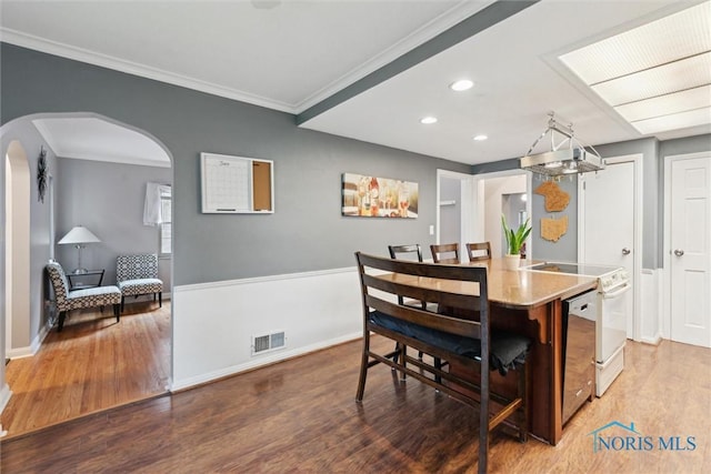 3127 Drummond Rd, Toledo, OH 43606 - dining area with arched walkways, wood finished floors, recessed lighting, baseboards, and crown molding