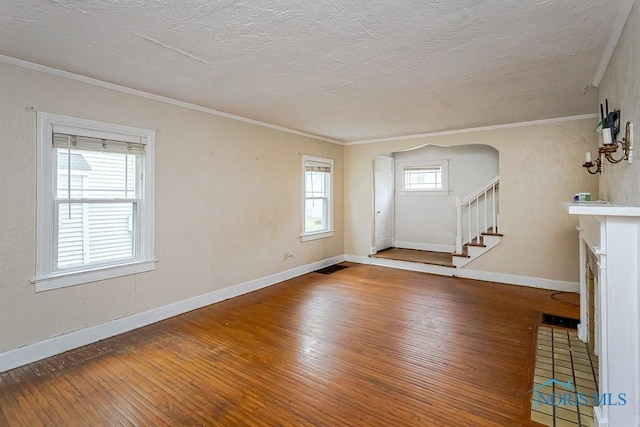 3819 Rushland Ave, Toledo, OH 43613 - unfurnished living room featuring wood-type flooring, healthy amount of natural light, stairs, ornamental molding, and a textured ceiling