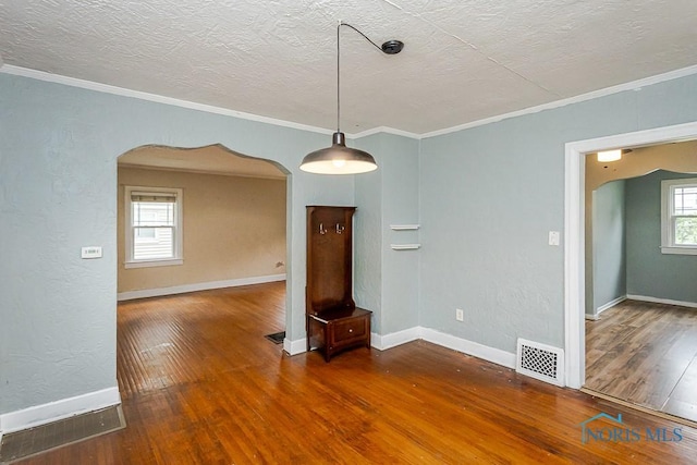 3819 Rushland Ave, Toledo, OH 43613 - unfurnished room with arched walkways, wood finished floors, crown molding, and a textured ceiling