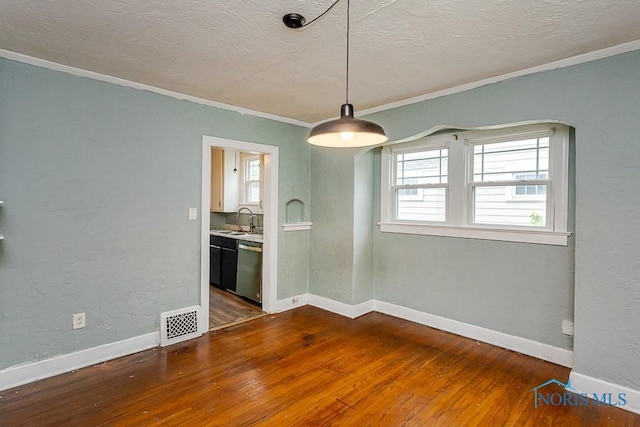 3819 Rushland Ave, Toledo, OH 43613 - unfurnished dining area with crown molding, dark wood-style flooring, plenty of natural light, and a textured ceiling