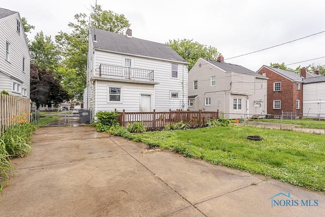 3819 Rushland Ave, Toledo, OH 43613 - rear view of property with a balcony, a gate, and a chimney