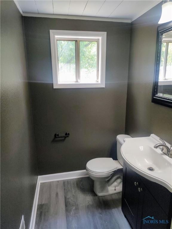 2417 Lambert Dr, Toledo, OH 43613 - half bathroom with wood finished floors, toilet, vanity, baseboards, and ornamental molding