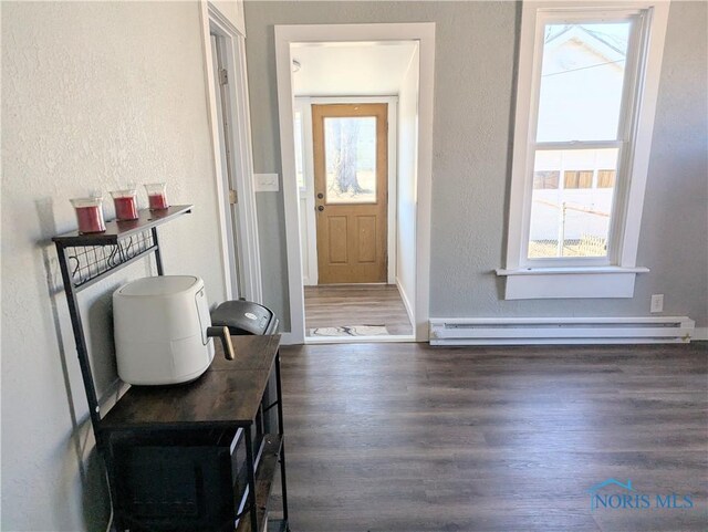726 S Lynn St, Bryan, OH 43506 - entrance foyer featuring baseboard heating, healthy amount of natural light, a textured wall, wood finished floors, and baseboards