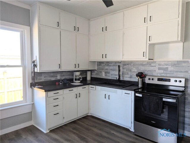 726 S Lynn St, Bryan, OH 43506 - kitchen with stainless steel electric range oven, a sink, decorative backsplash, dark wood-style flooring, and dark countertops