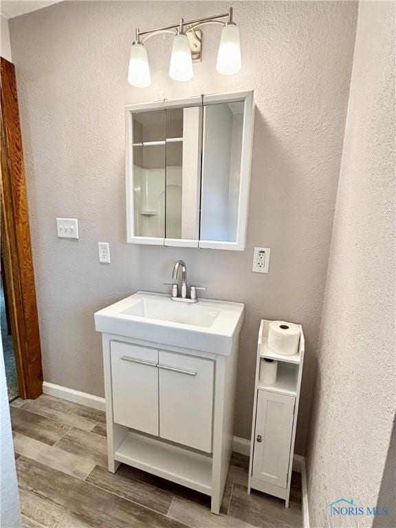 1522 Nevada St, Toledo, OH 43605 - bathroom with vanity, wood finished floors, baseboards, and a textured wall