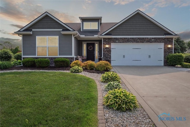 10 Hidden Village Ln, Holland, OH 43528 - craftsman-style house featuring driveway, a lawn, stone siding, and an attached garage