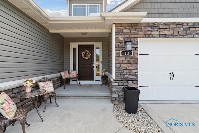 10 Hidden Village Ln, Holland, OH 43528 - doorway to property with stone siding and an attached garage