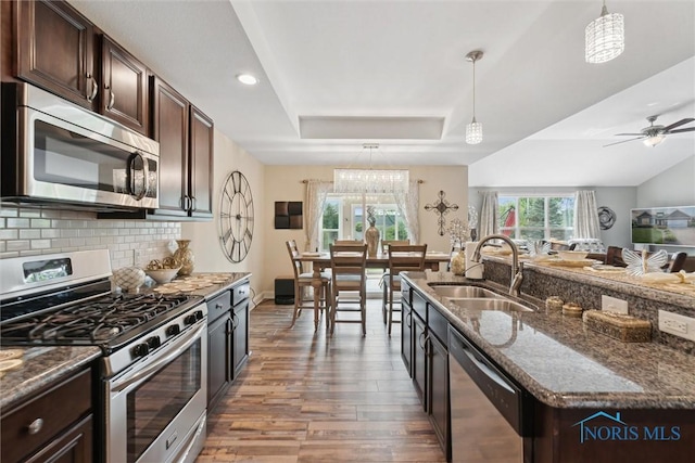 10 Hidden Village Ln, Holland, OH 43528 - kitchen featuring appliances with stainless steel finishes, wood finished floors, a tray ceiling, dark stone countertops, and dark brown cabinetry