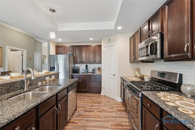 10 Hidden Village Ln, Holland, OH 43528 - kitchen with appliances with stainless steel finishes, a tray ceiling, light wood-style flooring, dark stone counters, and recessed lighting