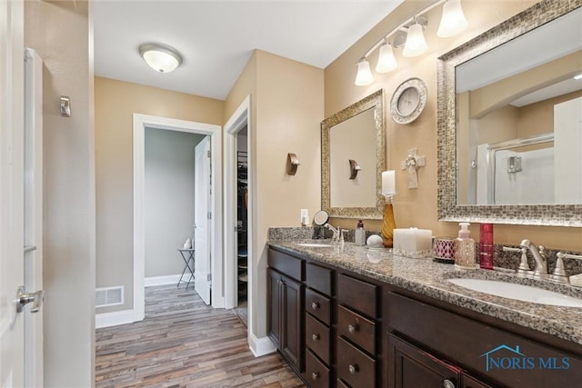 10 Hidden Village Ln, Holland, OH 43528 - full bathroom with wood finished floors, double vanity, a shower stall, and a walk in closet