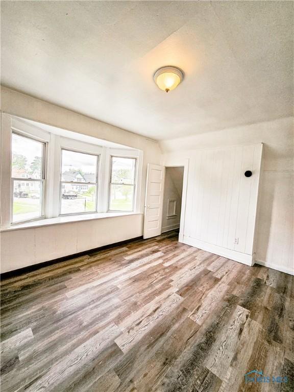 630 Highland Ave, Toledo, OH 43610 - unfurnished bedroom featuring wood finished floors and multiple windows