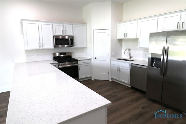 199 E Bridge Rd, Northwood, OH 43619 - kitchen featuring stainless steel appliances, a sink, dark wood finished floors, white cabinetry, and a peninsula