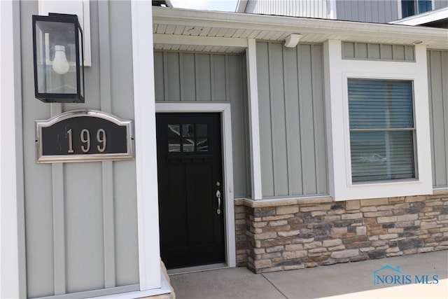 199 E Bridge Rd, Northwood, OH 43619 - doorway to property featuring stone siding and board and batten siding
