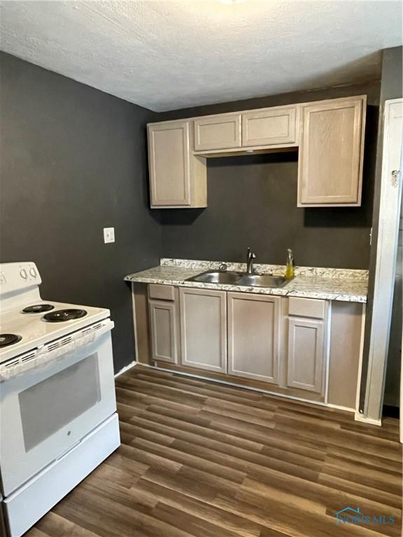 267 Licking St, Toledo, OH 43605 - kitchen featuring white range with electric stovetop, a sink, dark wood-type flooring, light countertops, and a textured ceiling