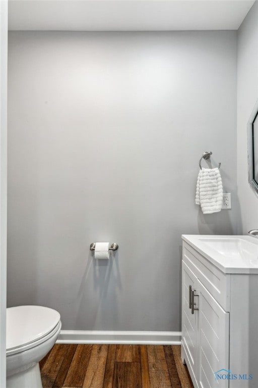 1313 Washington Ave, Findlay, OH 45840 - half bathroom featuring vanity, baseboards, toilet, and wood finished floors