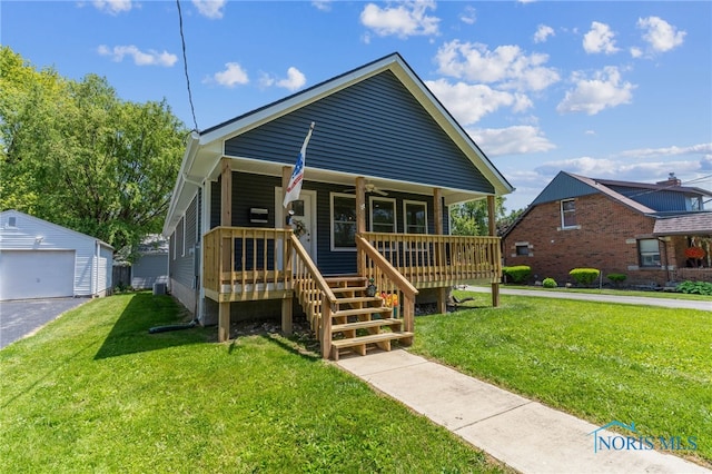 1313 Washington Ave, Findlay, OH 45840 - bungalow featuring an outdoor structure, a porch, a detached garage, and a front yard