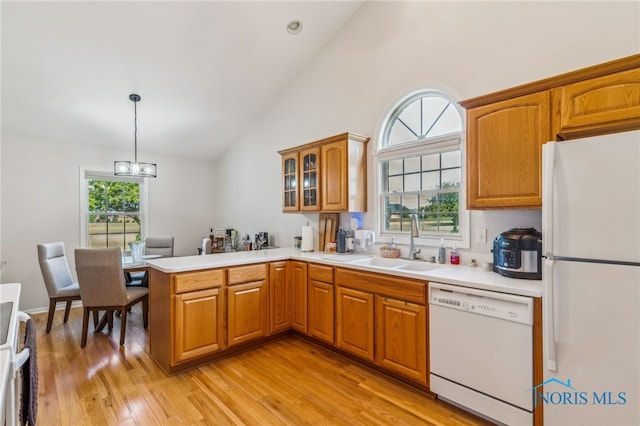 3112 Jacob Dr, Findlay, OH 45840 - kitchen with white appliances, a sink, a peninsula, brown cabinets, and high vaulted ceiling