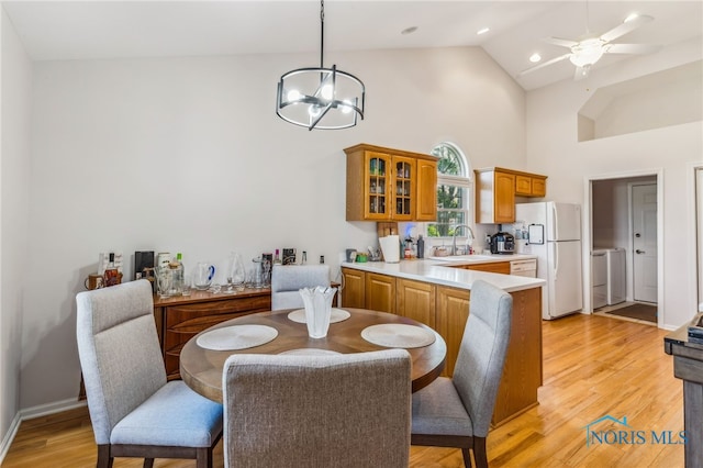3112 Jacob Dr, Findlay, OH 45840 - dining room featuring high vaulted ceiling, a chandelier, washing machine and clothes dryer, light wood finished floors, and ceiling fan